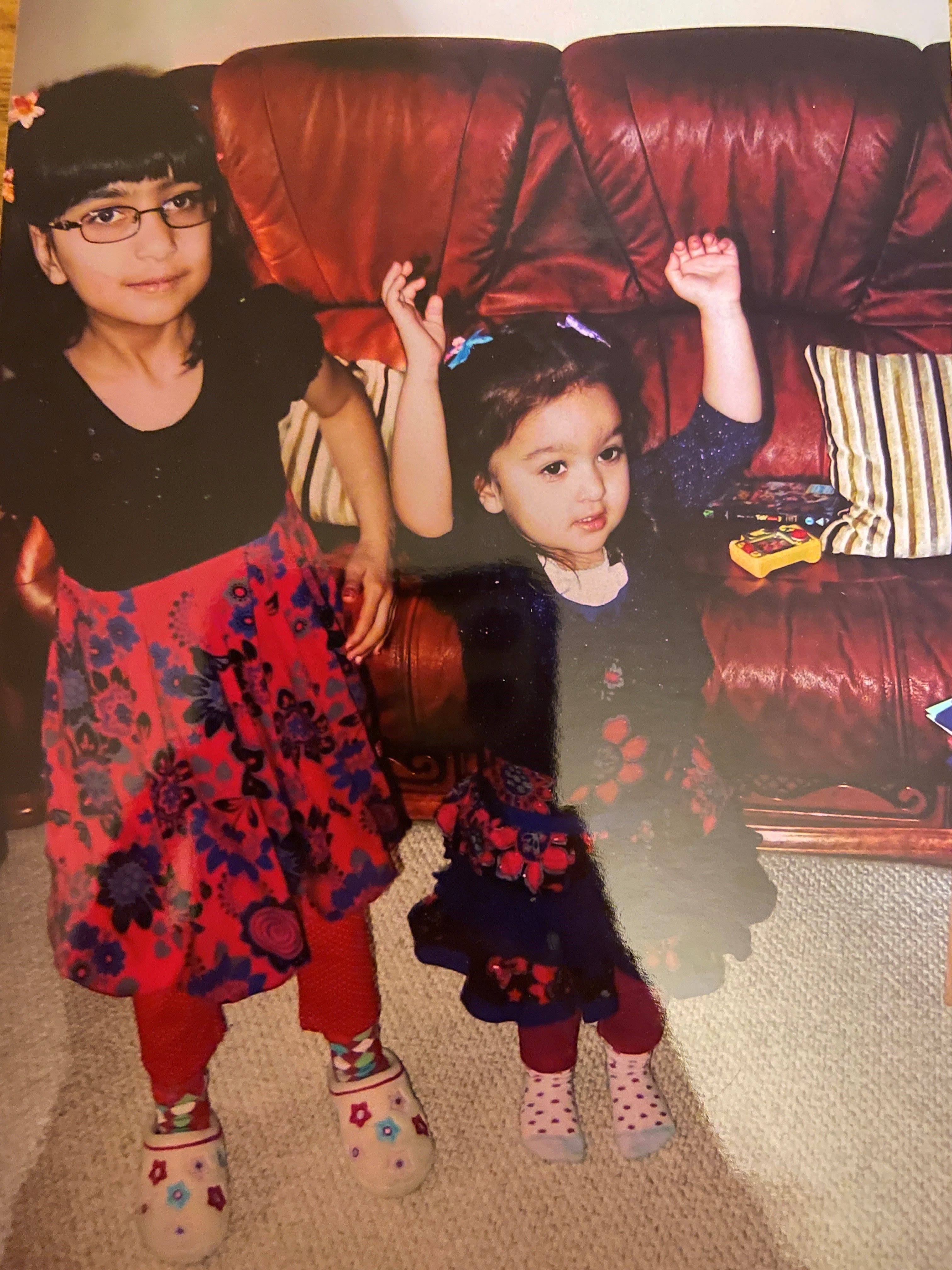 Alisha, age around 6, and her little sister smiling for the camera. 