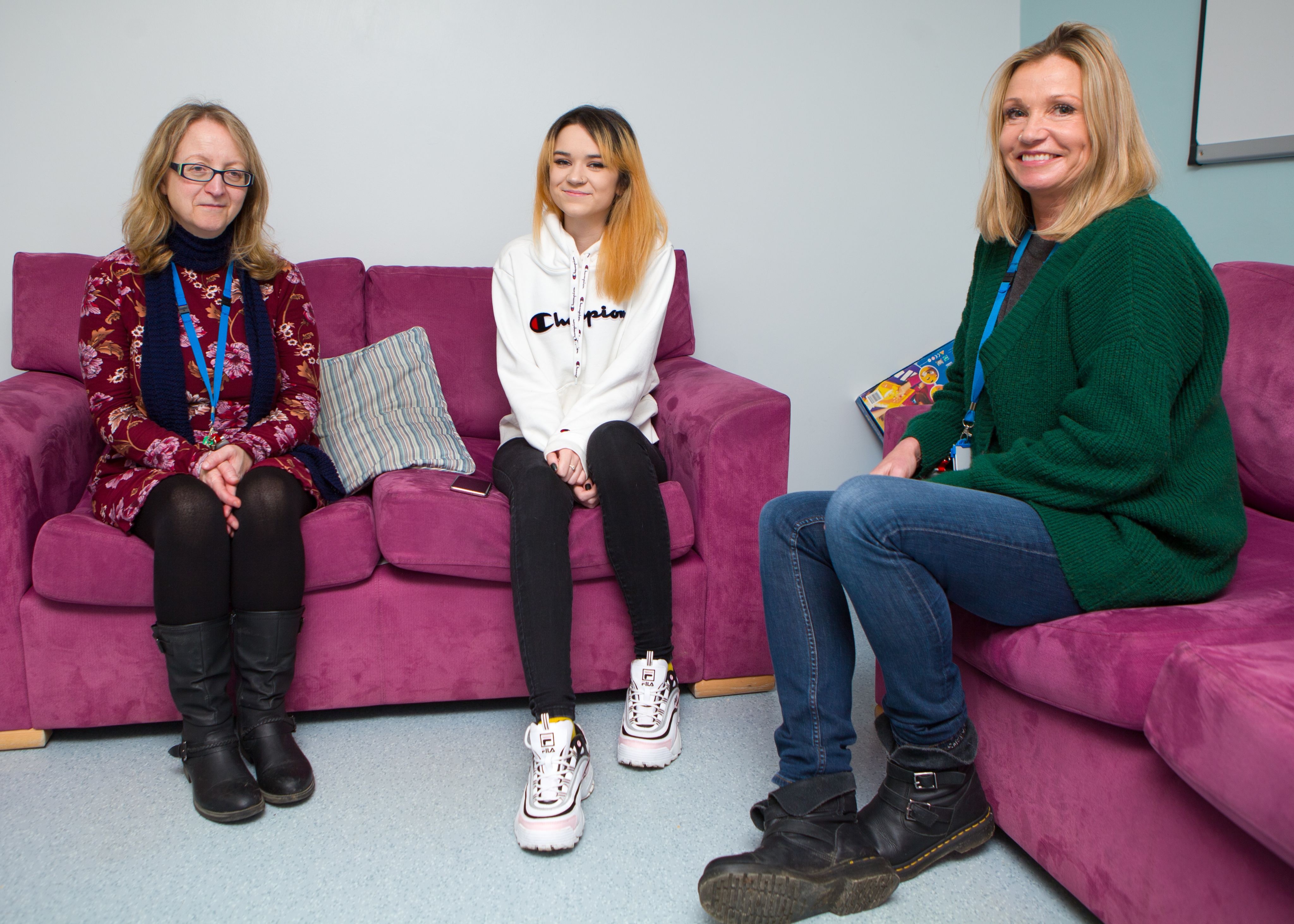 Teenage girl Ehlana sitting on sofa with a nurse and an activities coordinator from the Darwin Centre