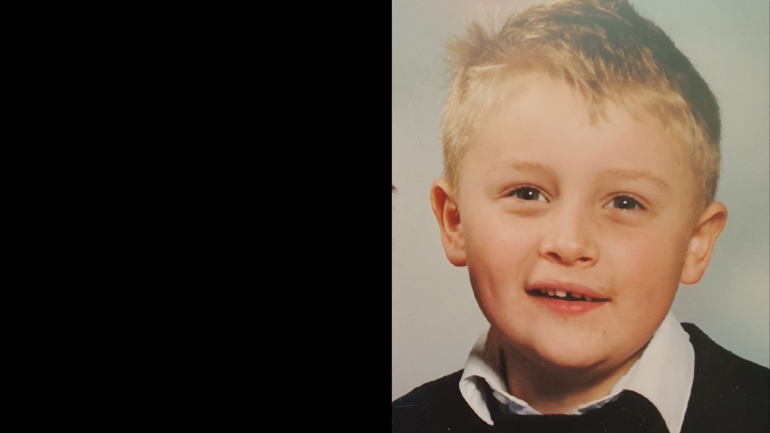 Liam age 6 with a gappy smile and a blue jumper.