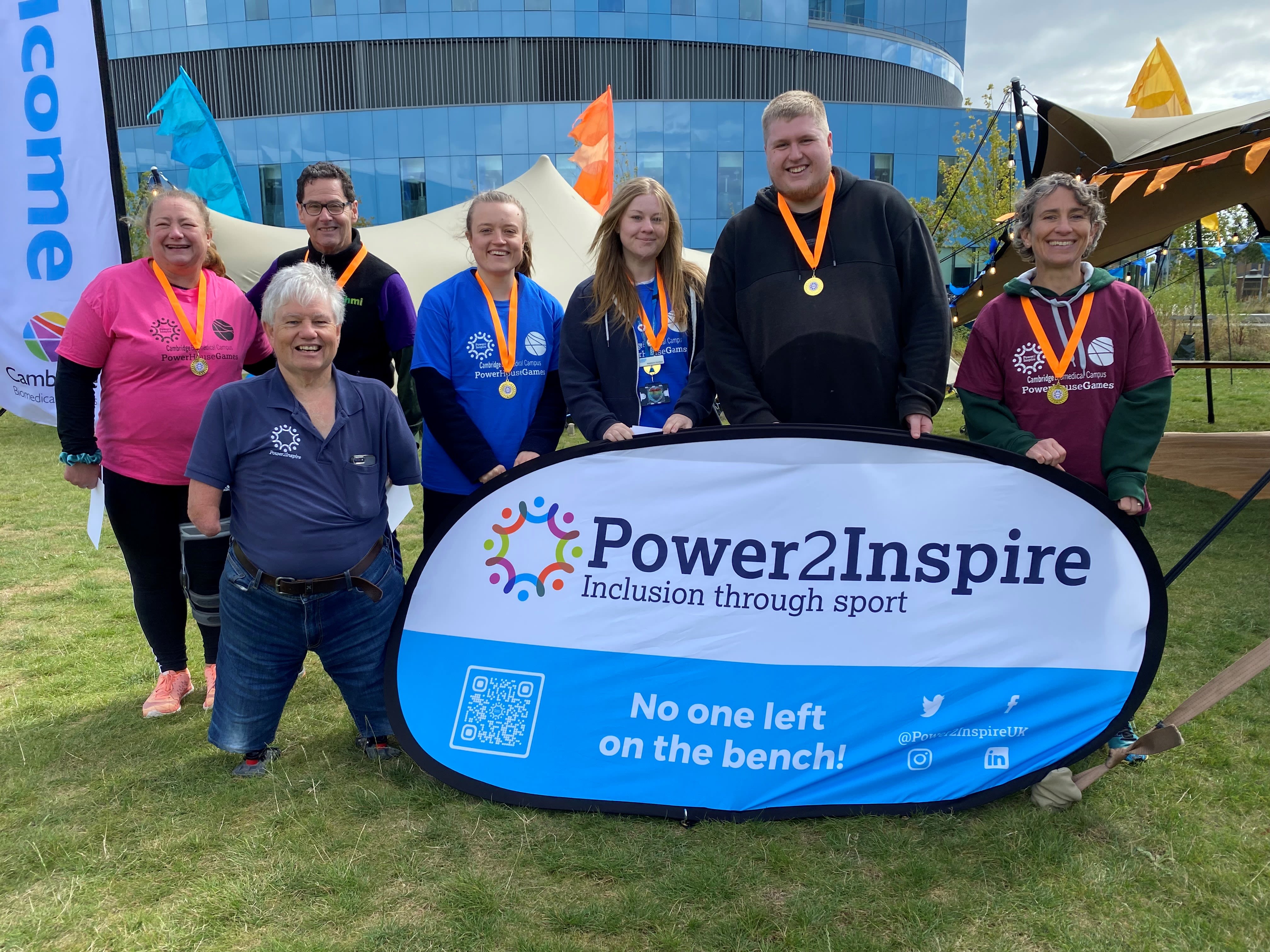 A group of people standing in the sun with medals around their neck after taking part in the inclusive sports event