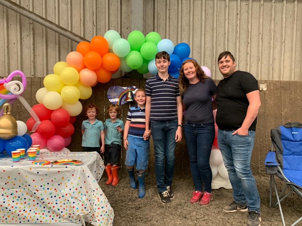 Niall with his mum, dad and three brothers, and the colourful balloon arch