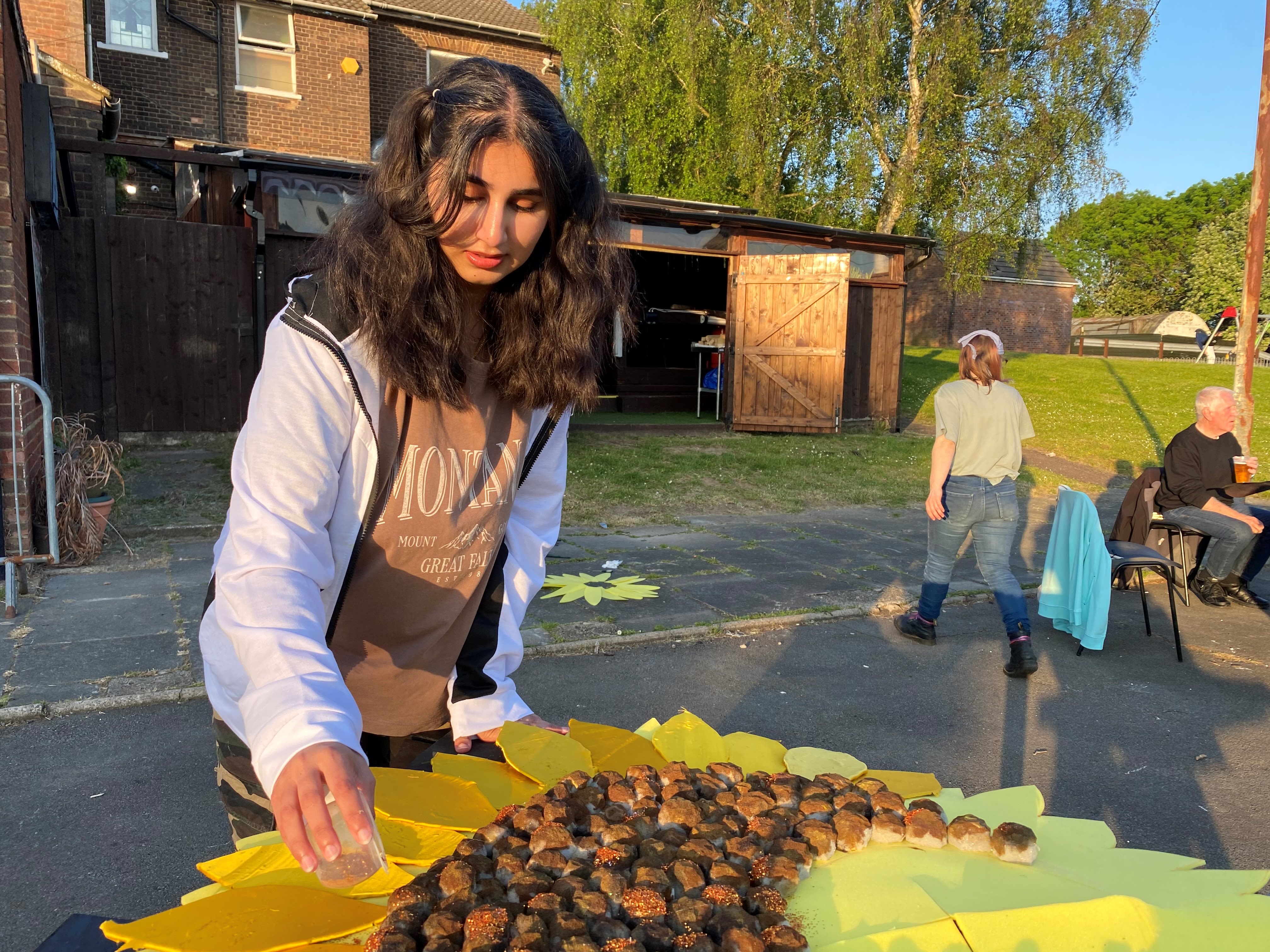 a girl gluing fake seeds onto a giant sunflower