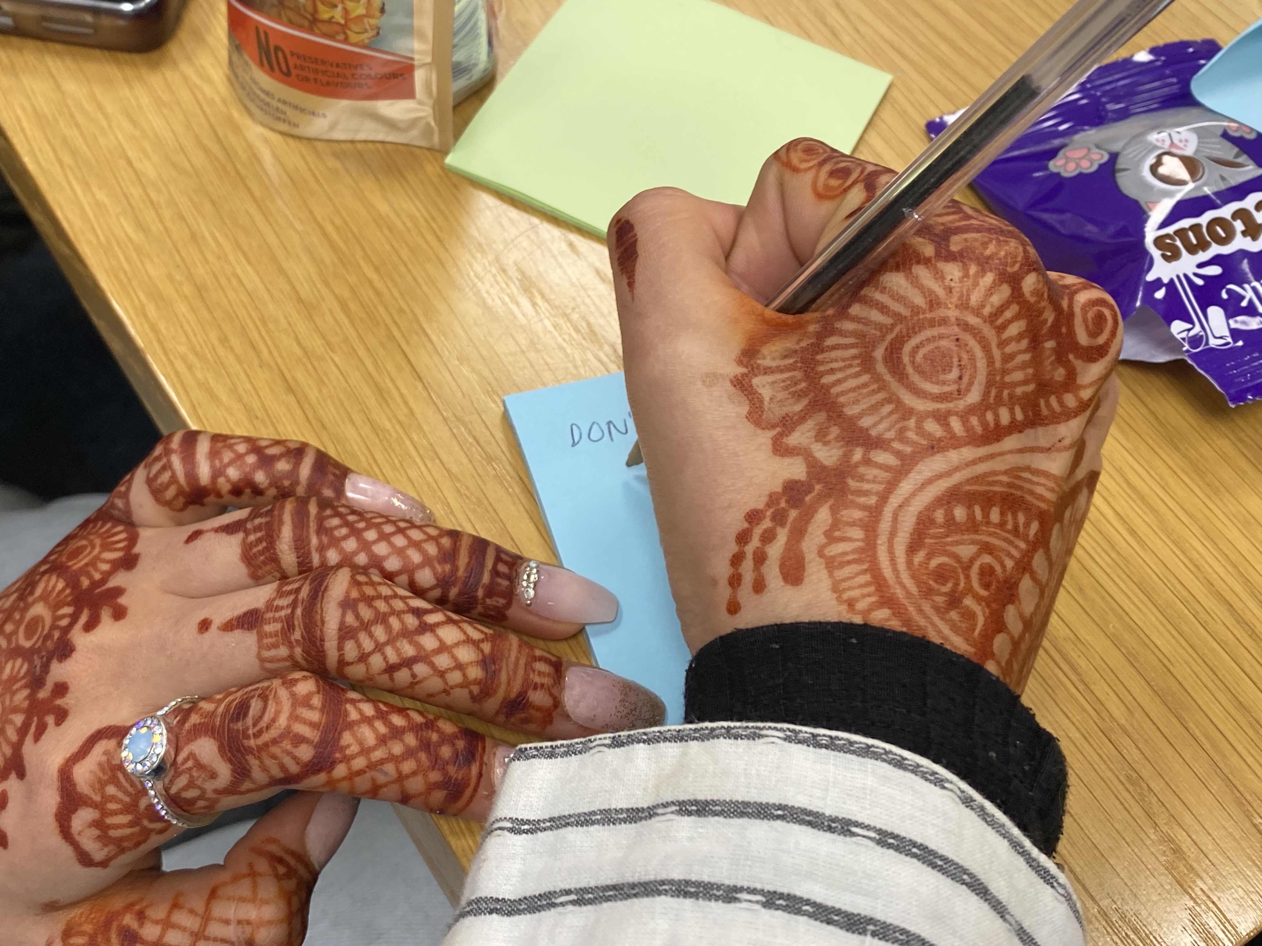 A hand decorated with henna in an intricate design