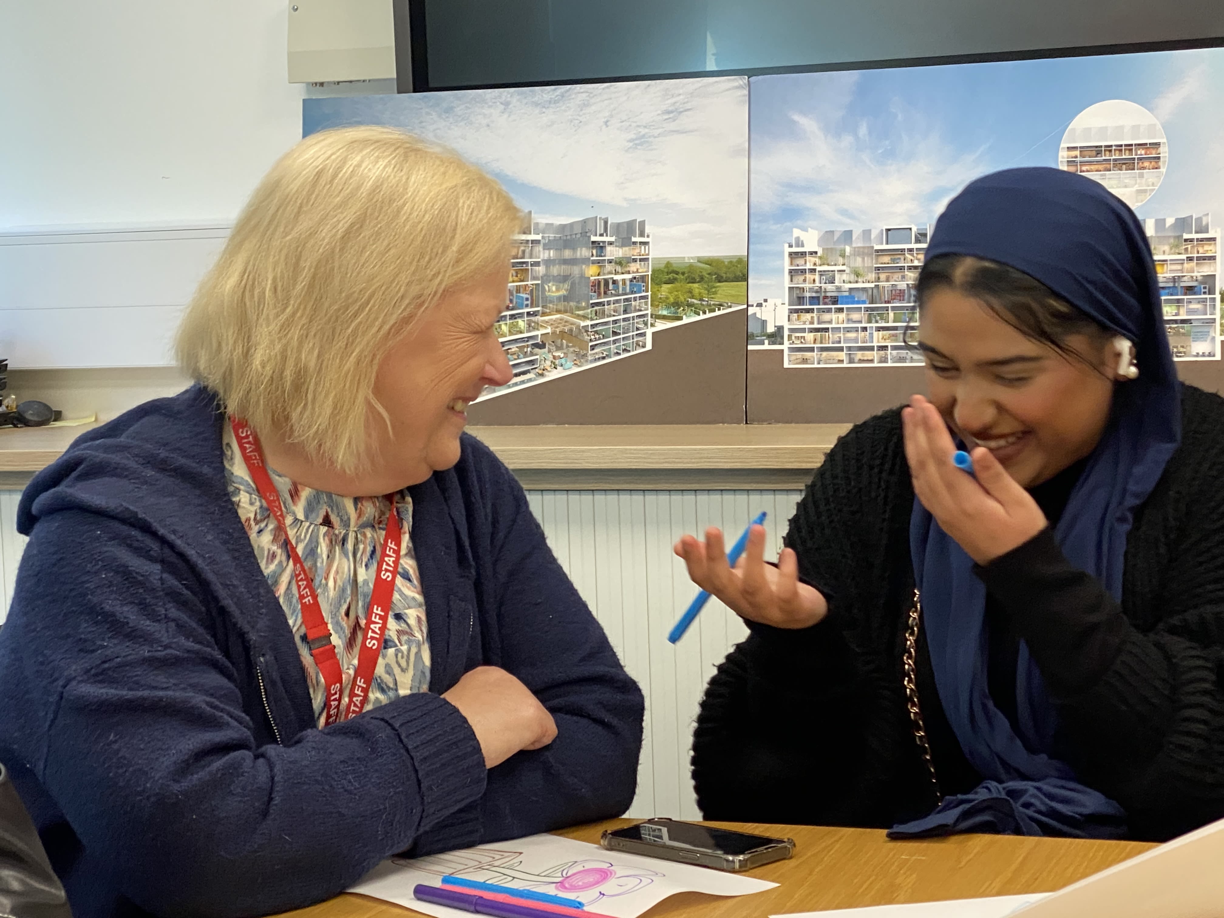 A female teacher laughing with a student