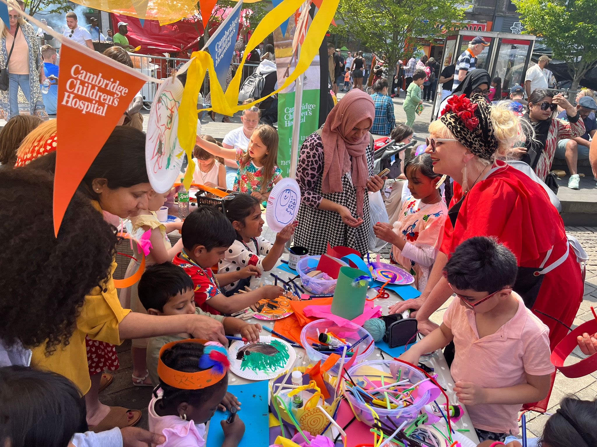 Lots of children working at a table doing arts and crafts